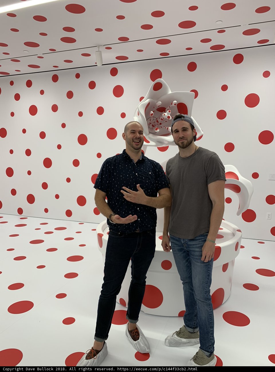 Two Men Standing in Front of a Bold Polka Dot Wall