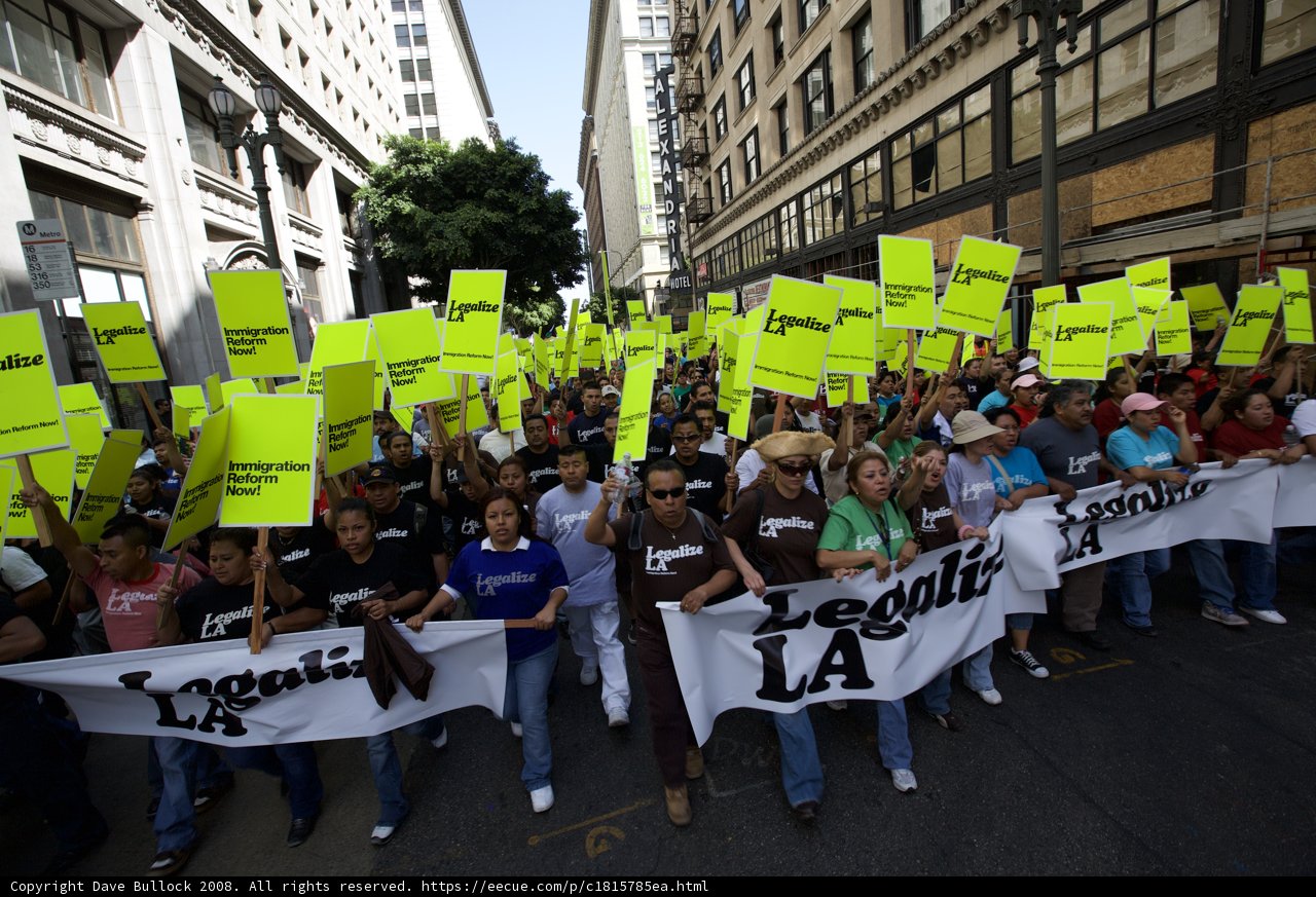 Mayday Rally Protesters Hold Signs in a Busy Street