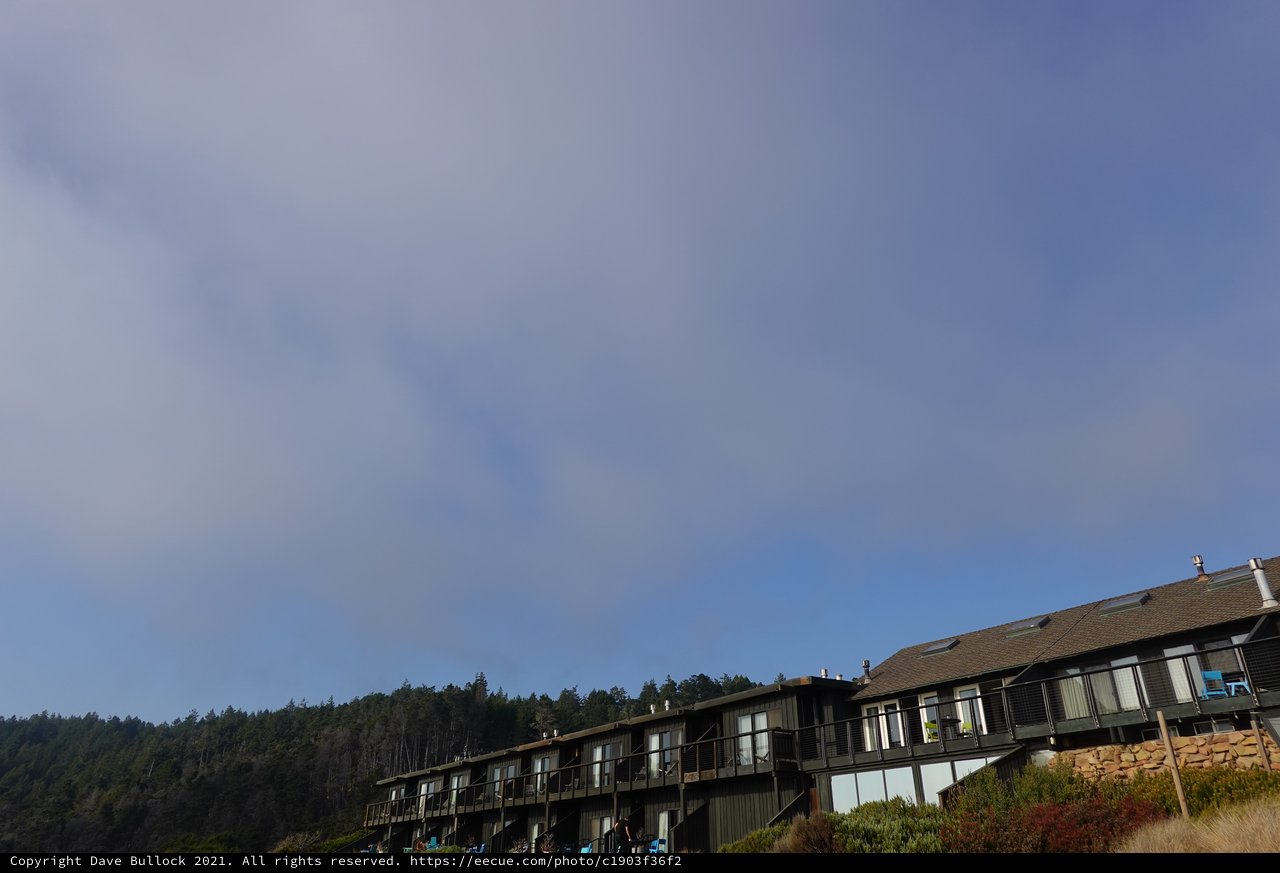 Modern Hillside Condominiums Against Forested Mountains