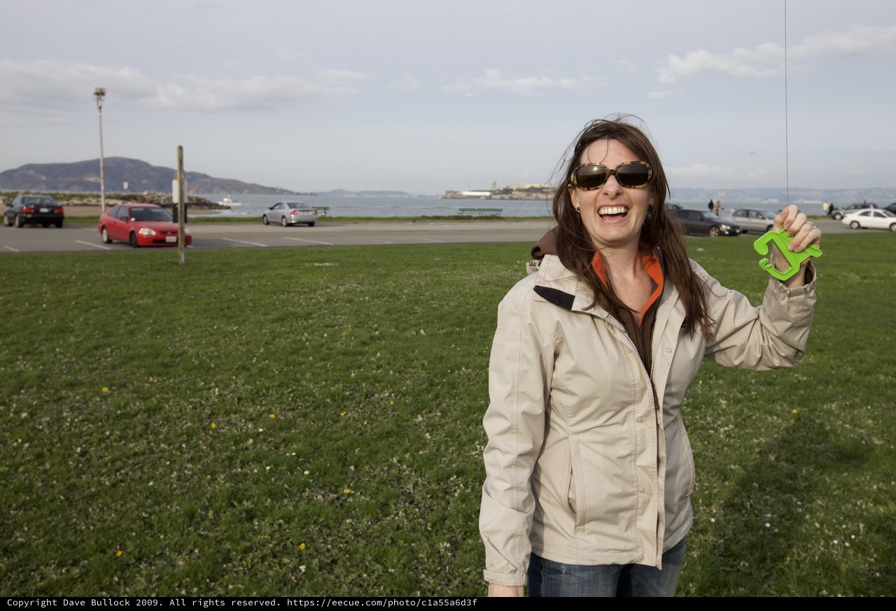 Laughing Woman Holds Green Number at San Francisco Waterfront