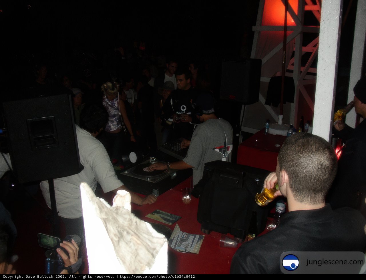 Nightlife in Ensenada Caption: A group of 11 people gather around a table with a DJ as speakers blare music in a nightclub in Ensenada, Baja California, Mexico in 2002.