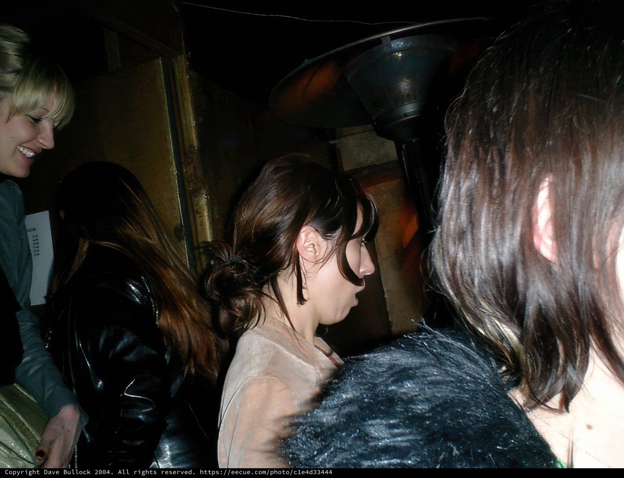 Black-Haired Woman in Leather Jacket at Pub