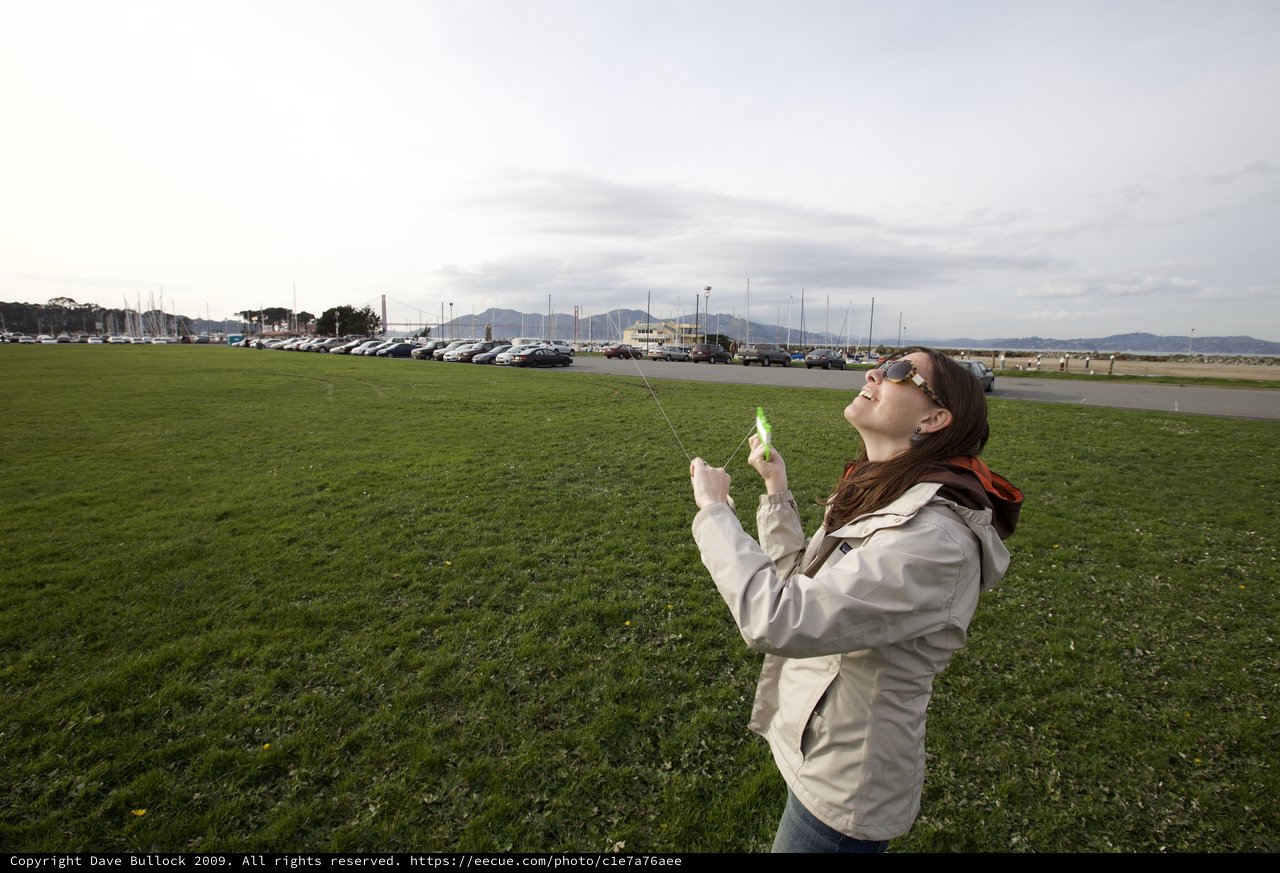 Woman Flying a Kite Near the Golden Gate Bridge