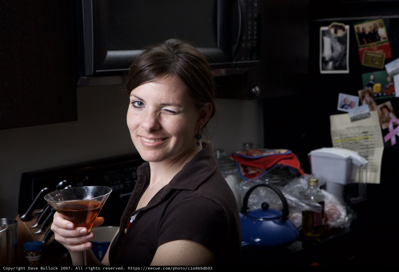 Woman Winking with Cocktail in Home Kitchen