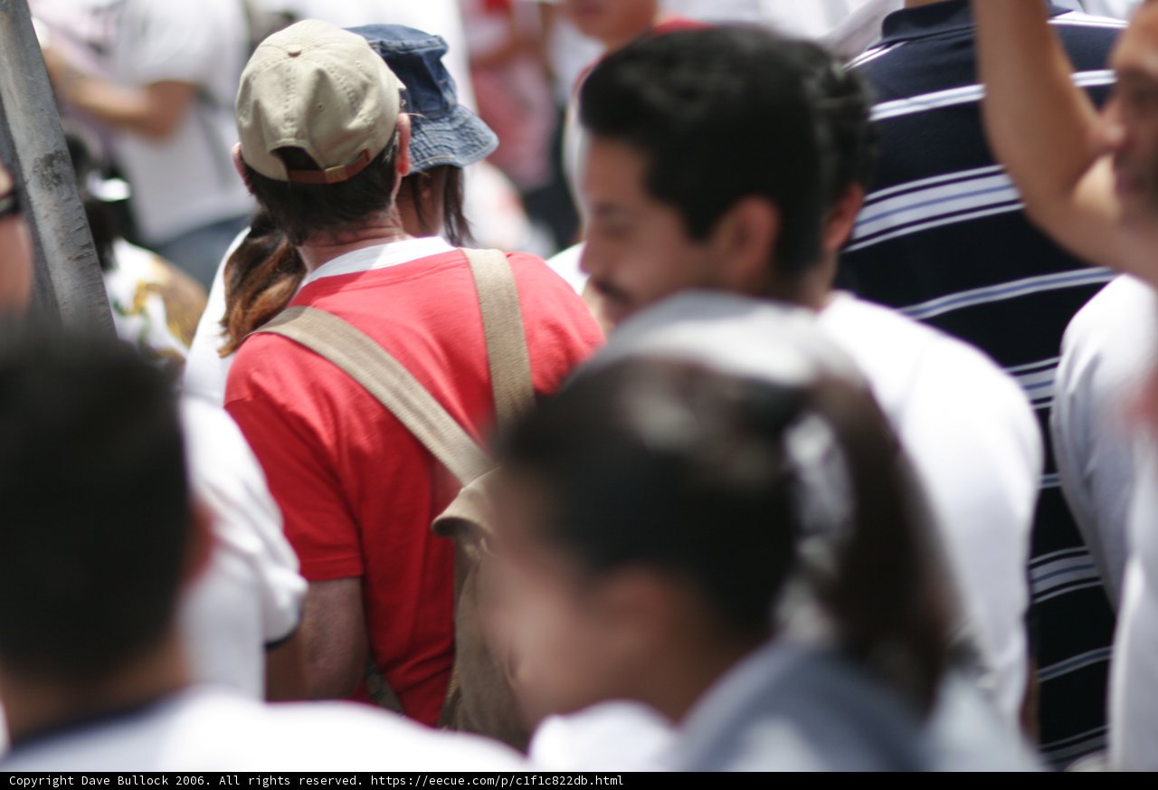 Hat-wearing man in a crowd