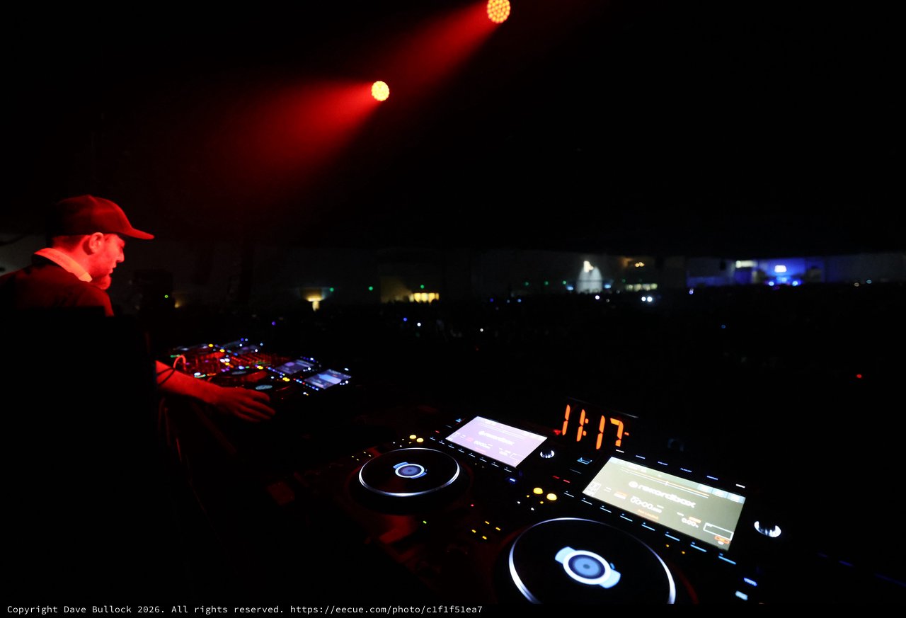 DJ Drops Bass Under Red Stage Lights at Night