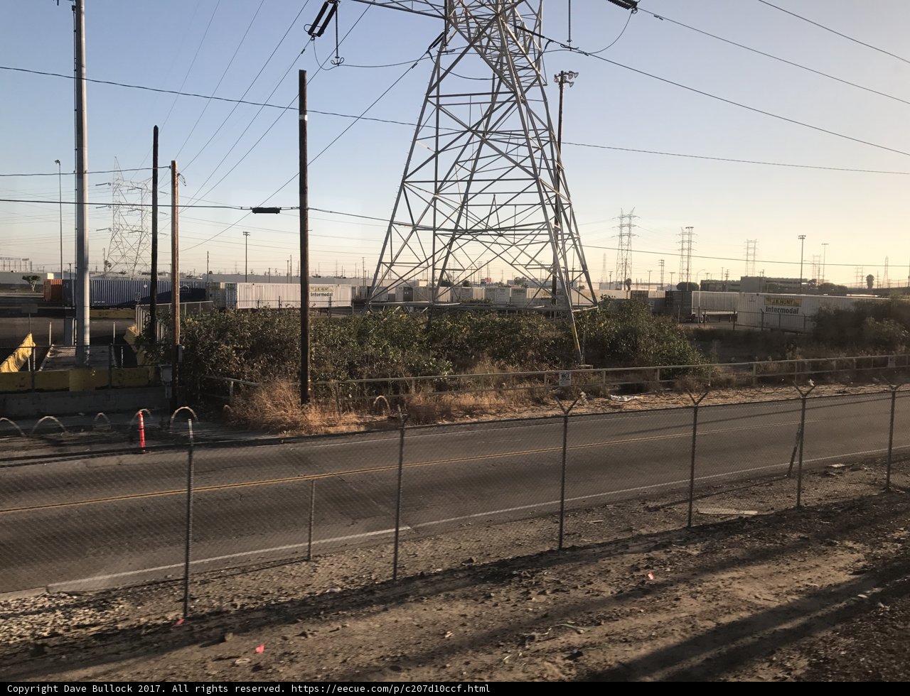 Electric Tower and Fence Against Blue Sky