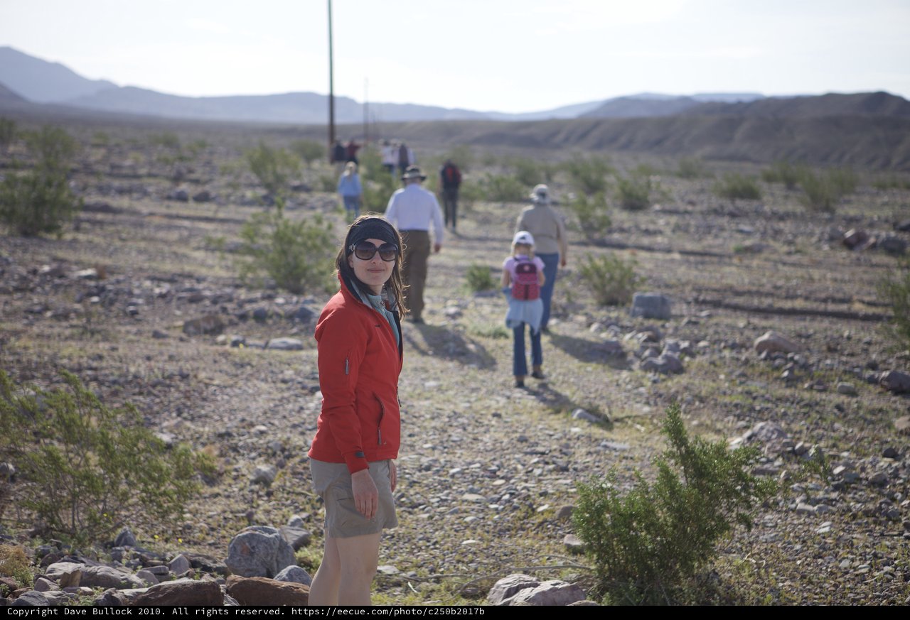 Desert Hiker Pauses on Rocky Trail Amid Group