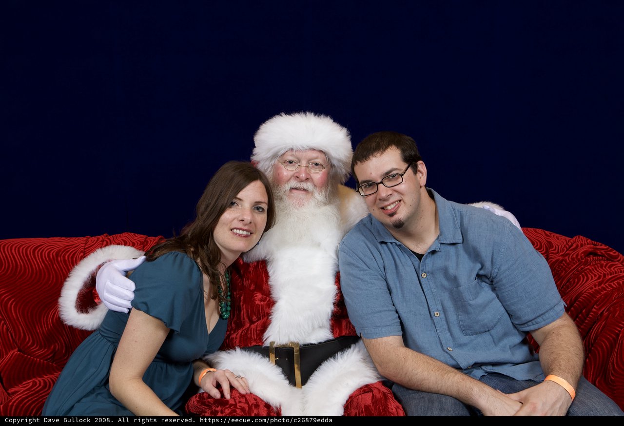 Couple Poses with Santa at Christmas Party
