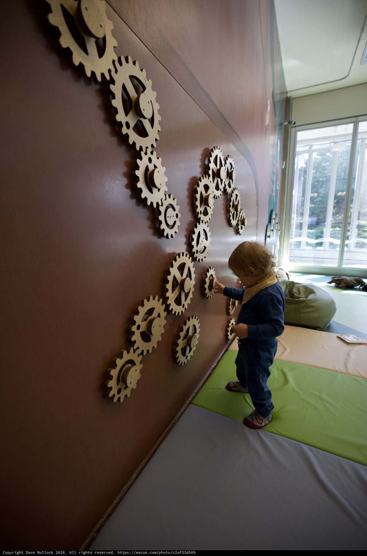 Child Exploring Interactive Gear Wall Installation