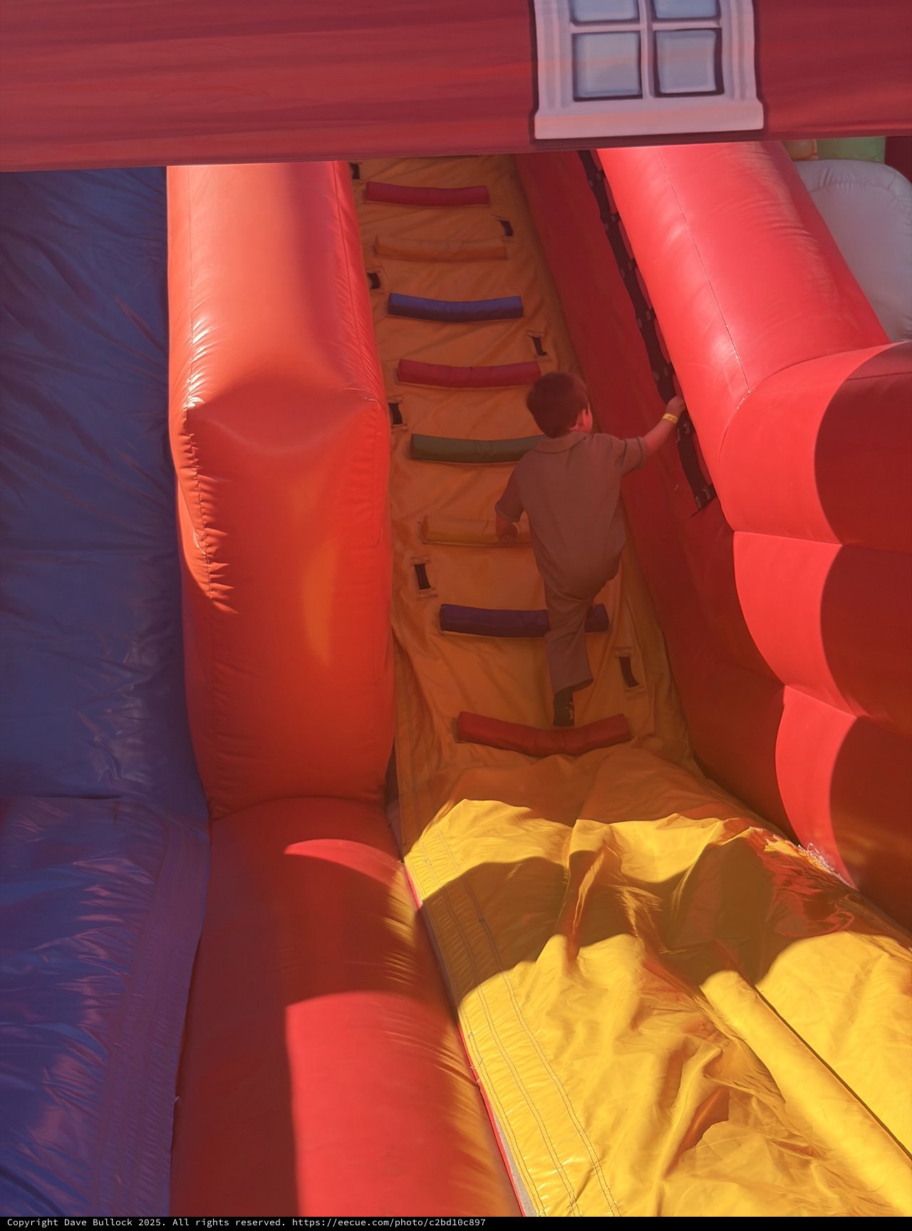 Child Climbing Through Inflatable Bounce House Obstacle