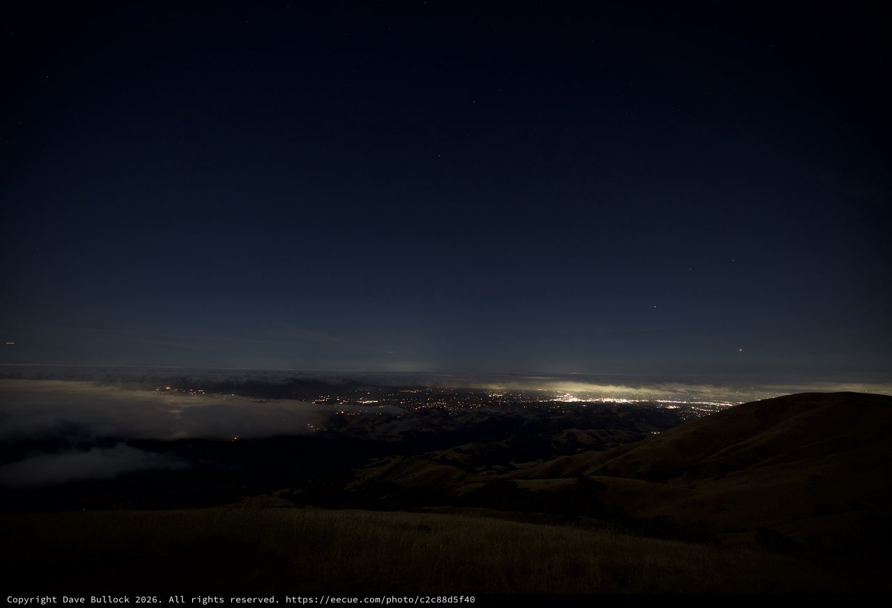 City Lights Glowing Beneath a Sea of Fog
