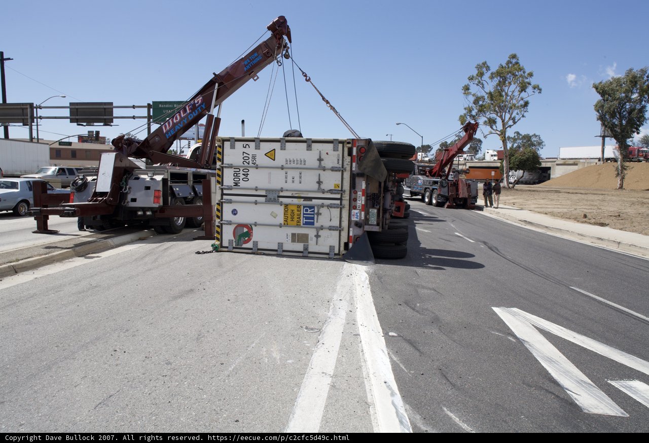 Crane lifts overturned truck off the road