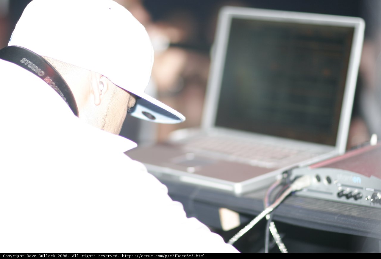 Man in White Shirt Works on Laptop