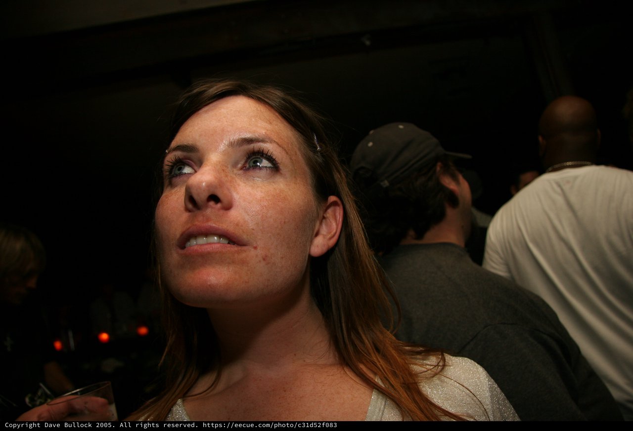 Woman Gazing Upward at Dimly Lit Nightclub