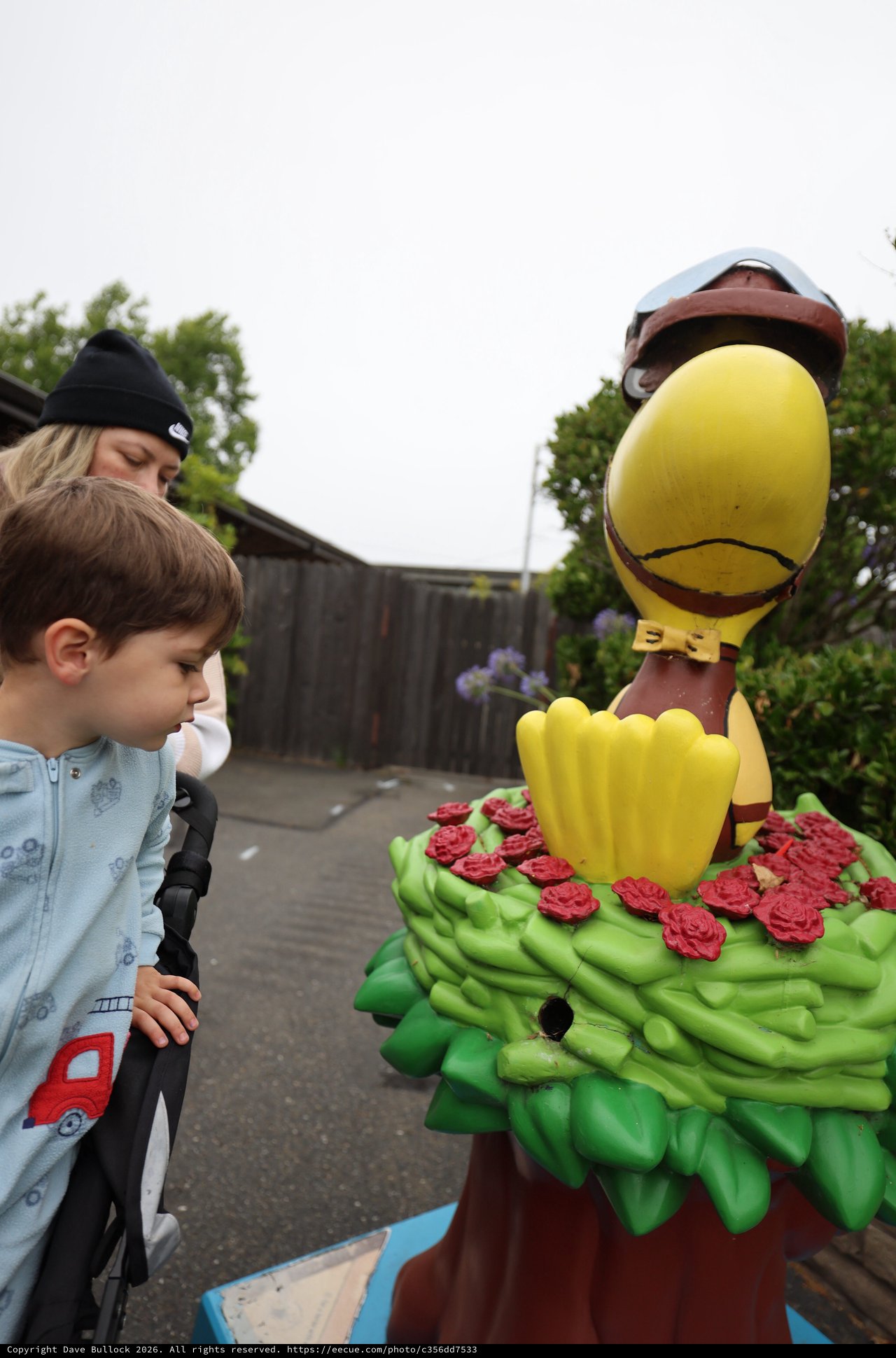 Child's Wonder at Colorful Duck Mascot Statue