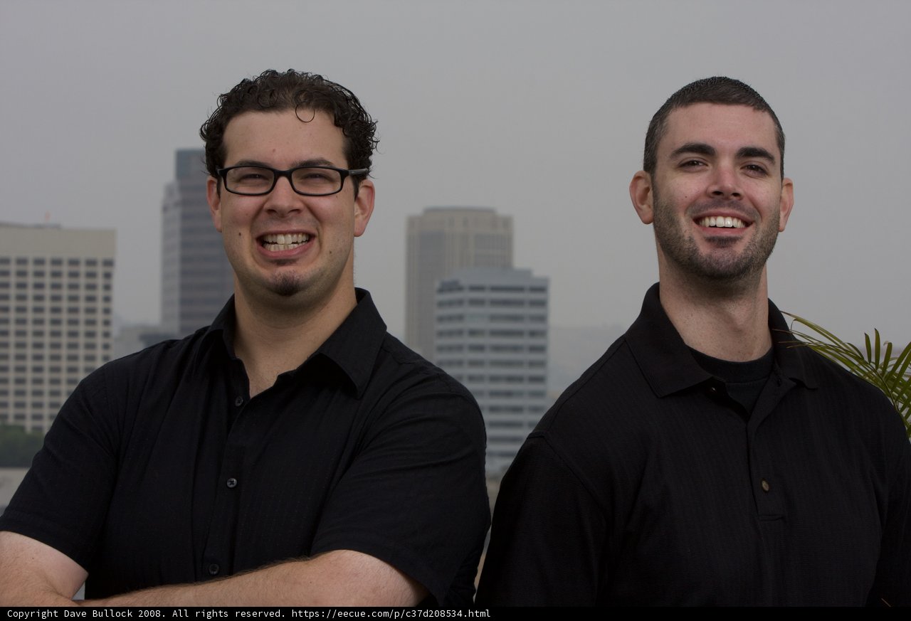Two Men with Spectacles in Front of Skyscraper