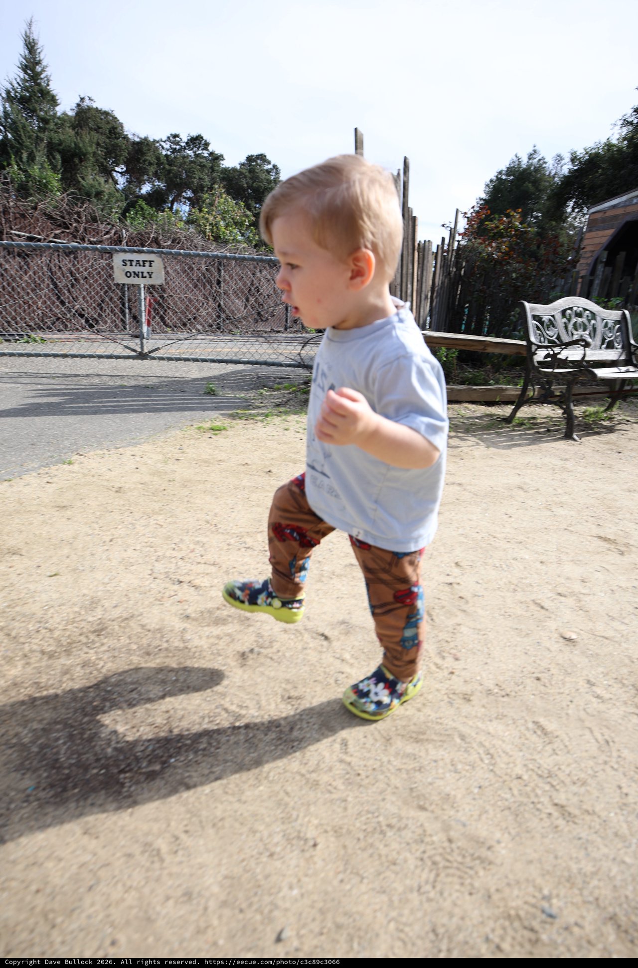 Toddler Running Joyfully Through Sandy Play Area