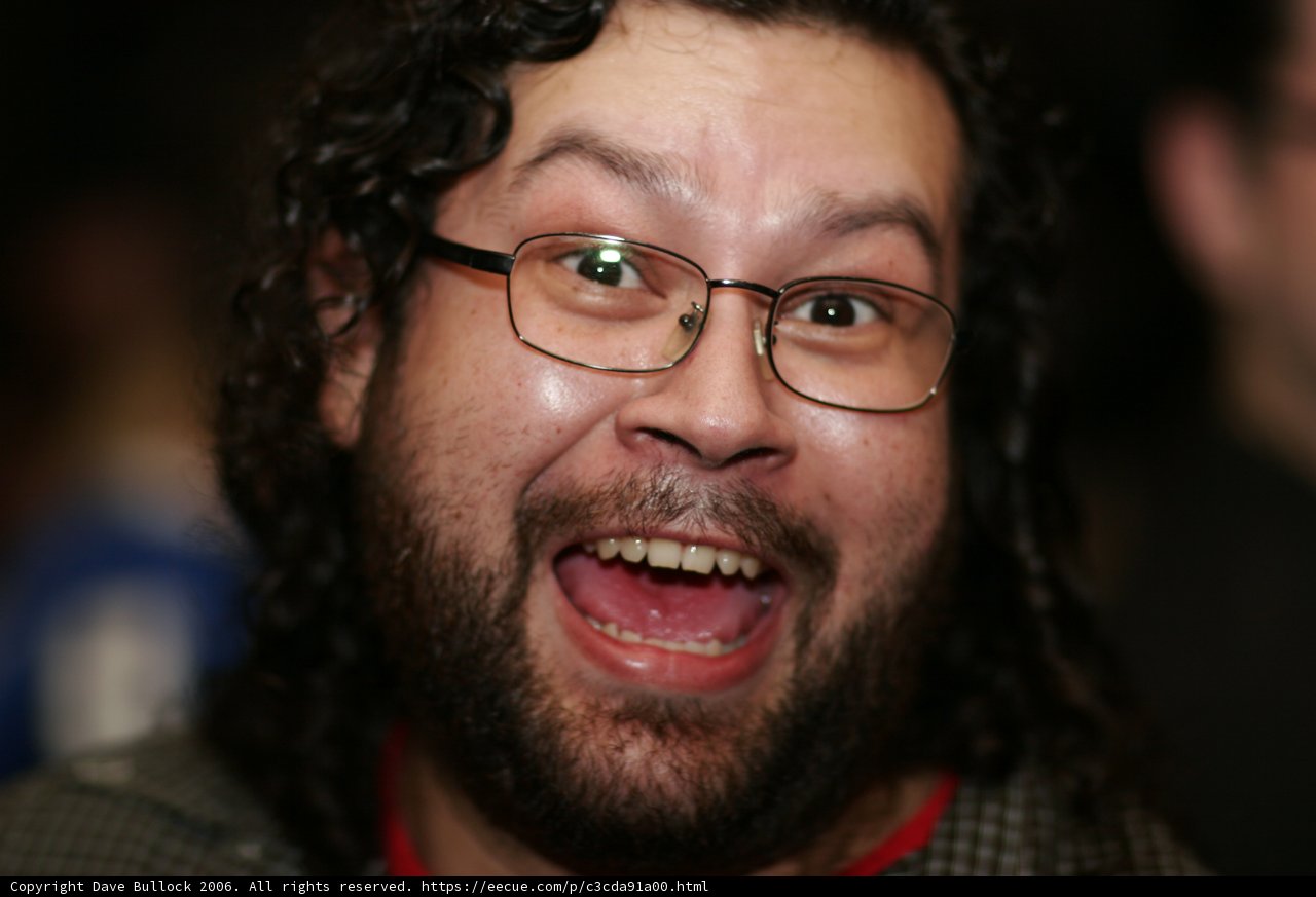 Smiling Man with Long Hair and Glasses