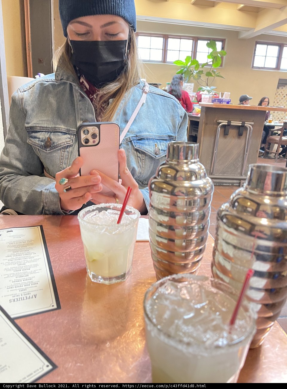 Masked Woman Enjoying a Drink Indoors