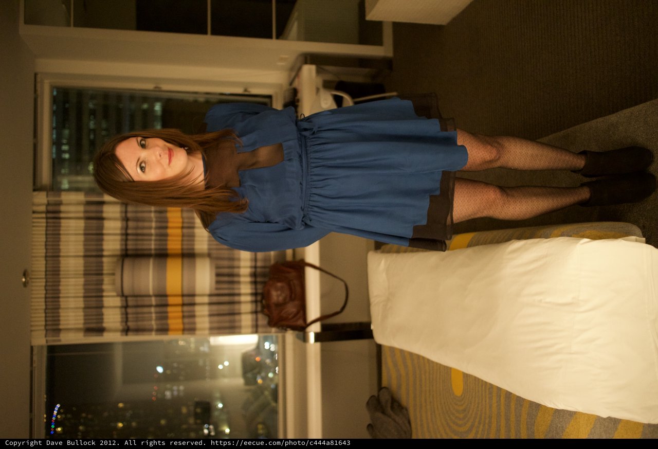 Woman in Blue Dress Poses in Hotel Room