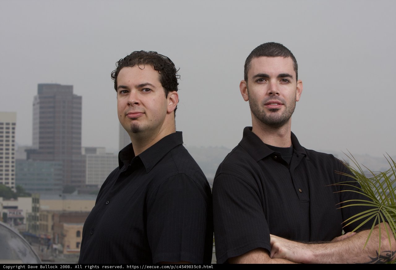 Two Happy Men in Black Shirts with Skyscrapers in the Background
