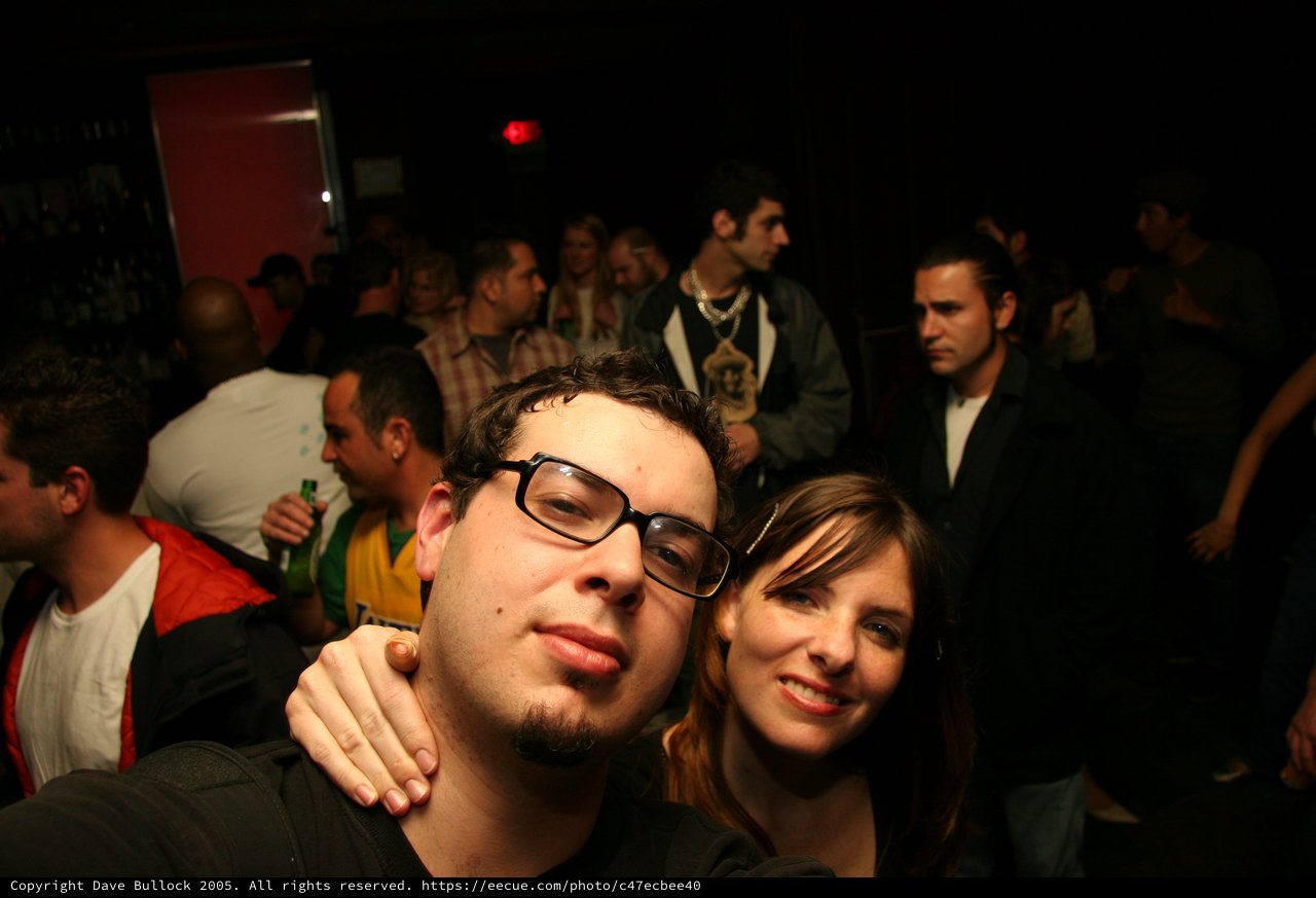 Friends Posing Together at a Crowded Nightclub