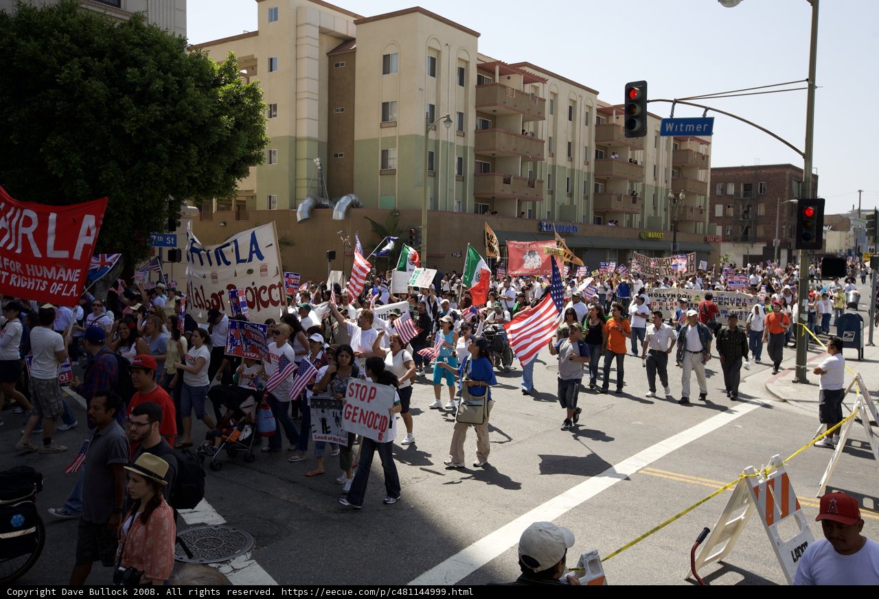 Mayday Rally Participants Walk Down Busy Street Holding Signs