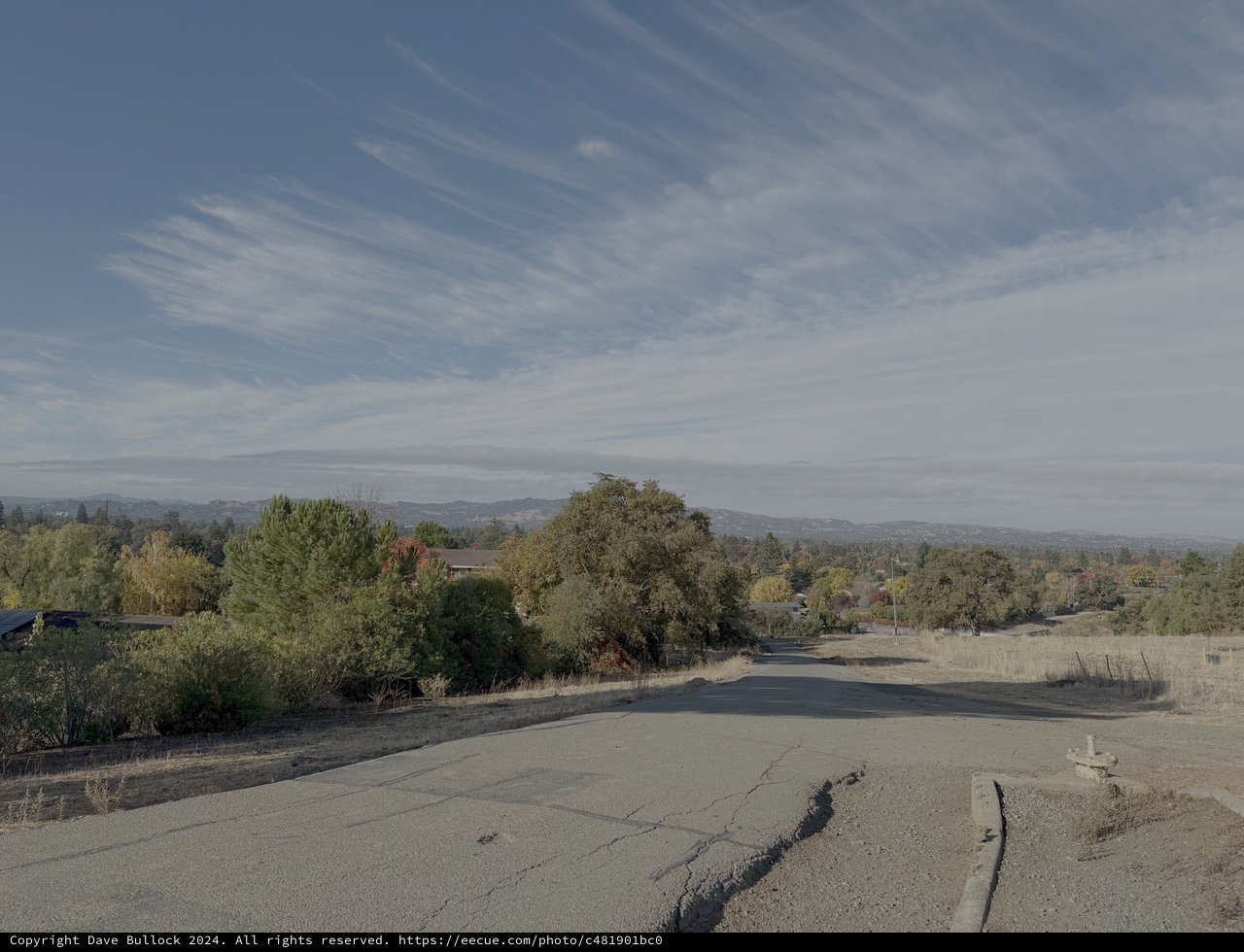 Cracked Rural Road with Mountain Vista