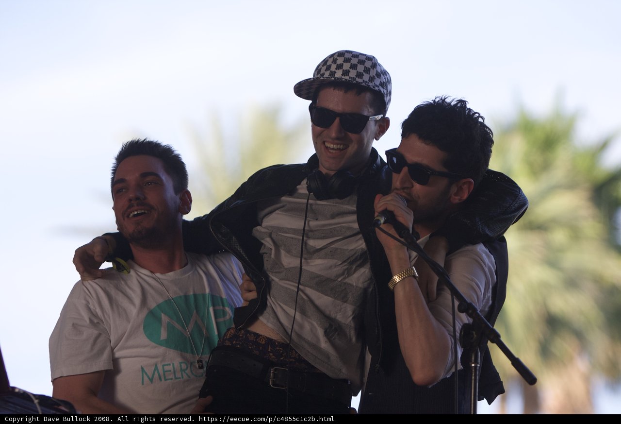 Three Entertainers Performing on Stage with Microphone