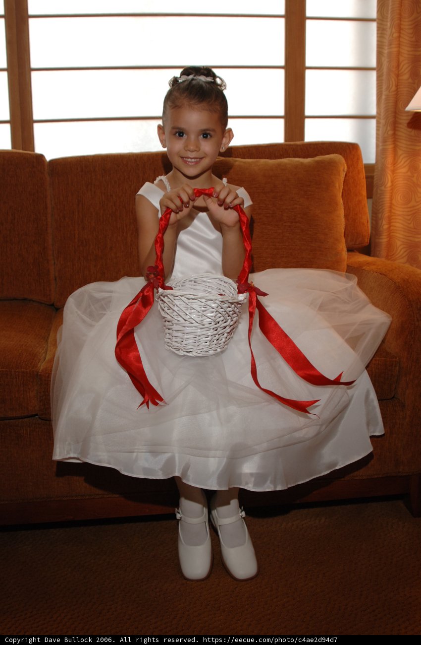 Little Girl in White Dress Sitting on a Chair