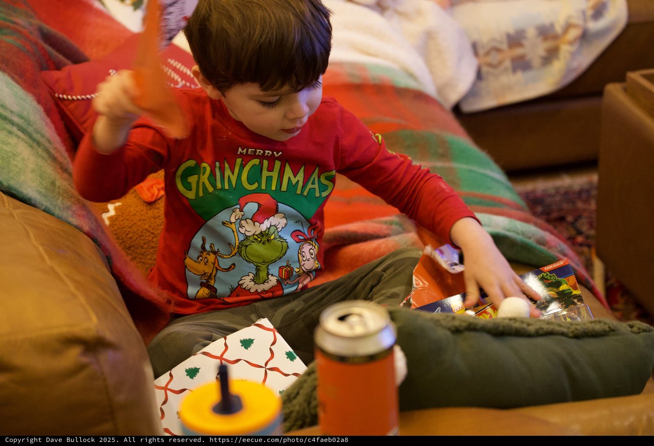 Child Opening Christmas Presents in Grinch Pajamas