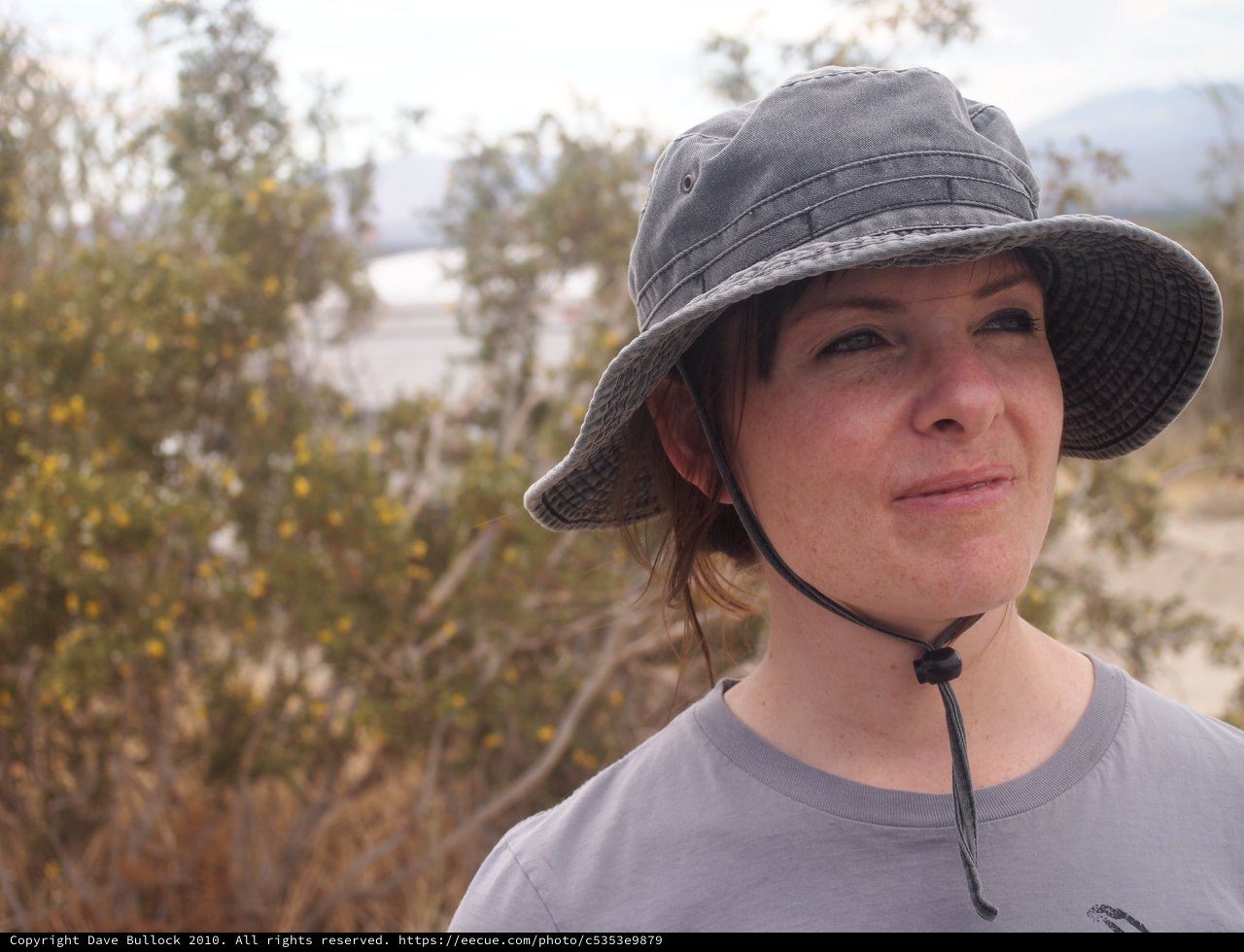 Woman in Sun Hat Gazes Across Desert Landscape