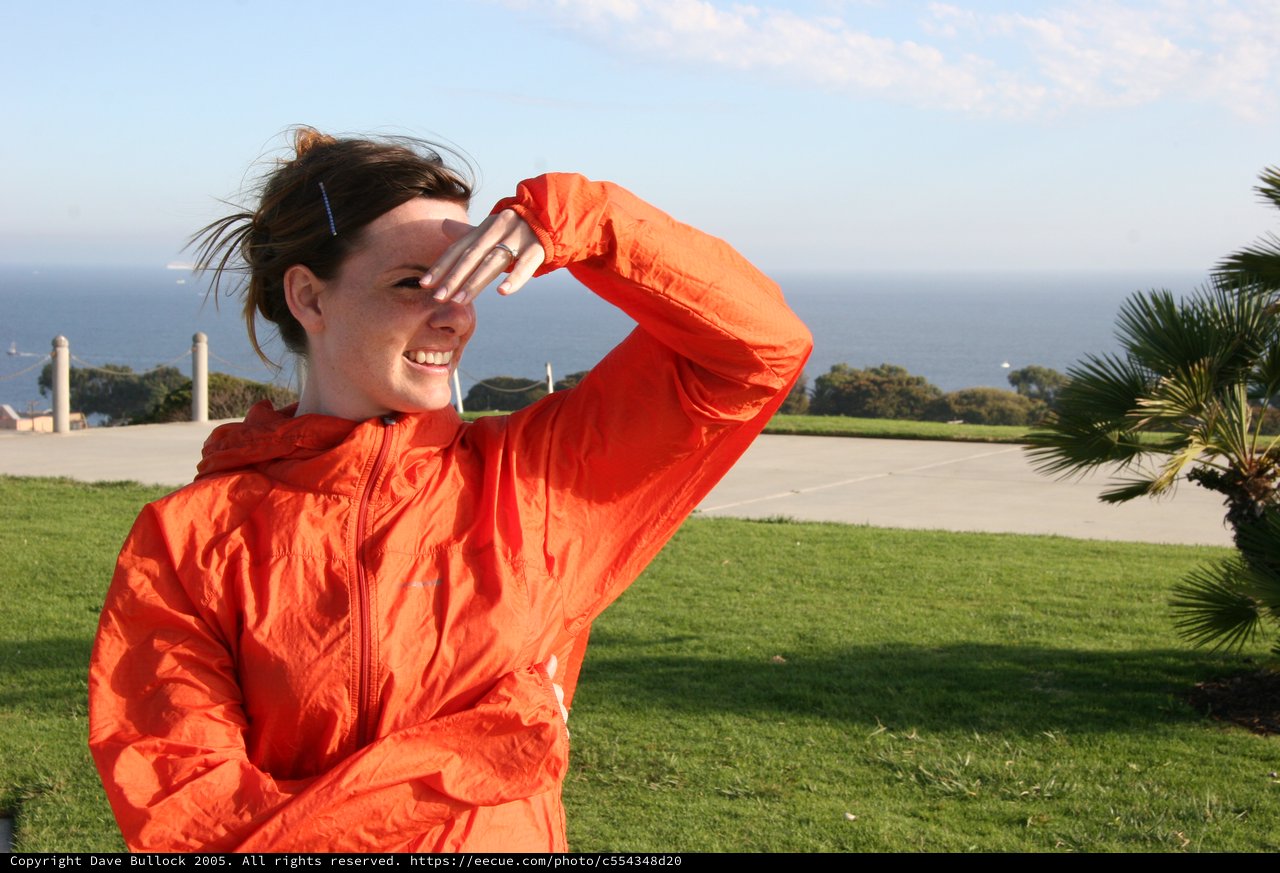 Windswept Woman Shielding Eyes by the Sea