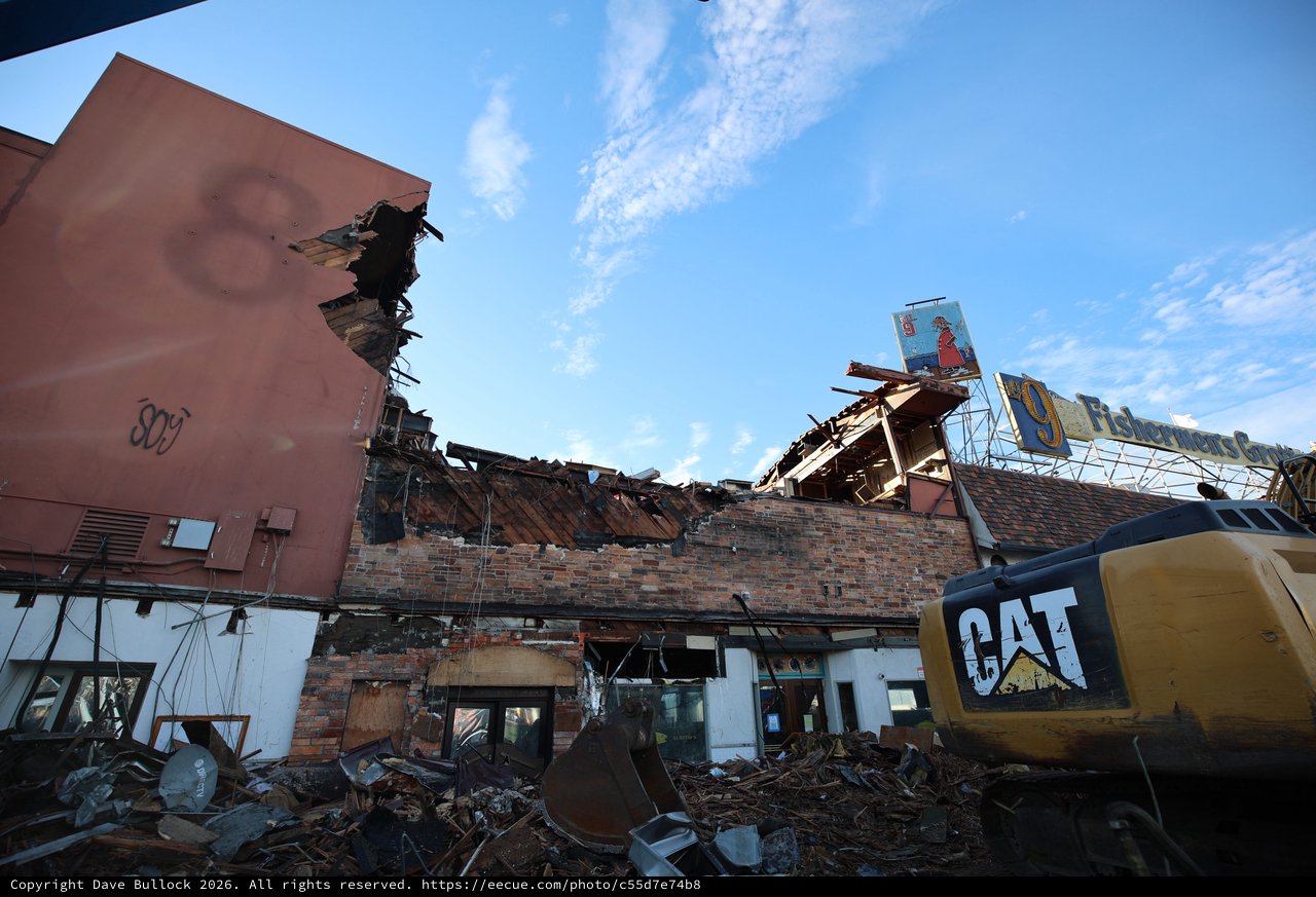Demolished Building Under Clear Blue Sky with CAT Excavator