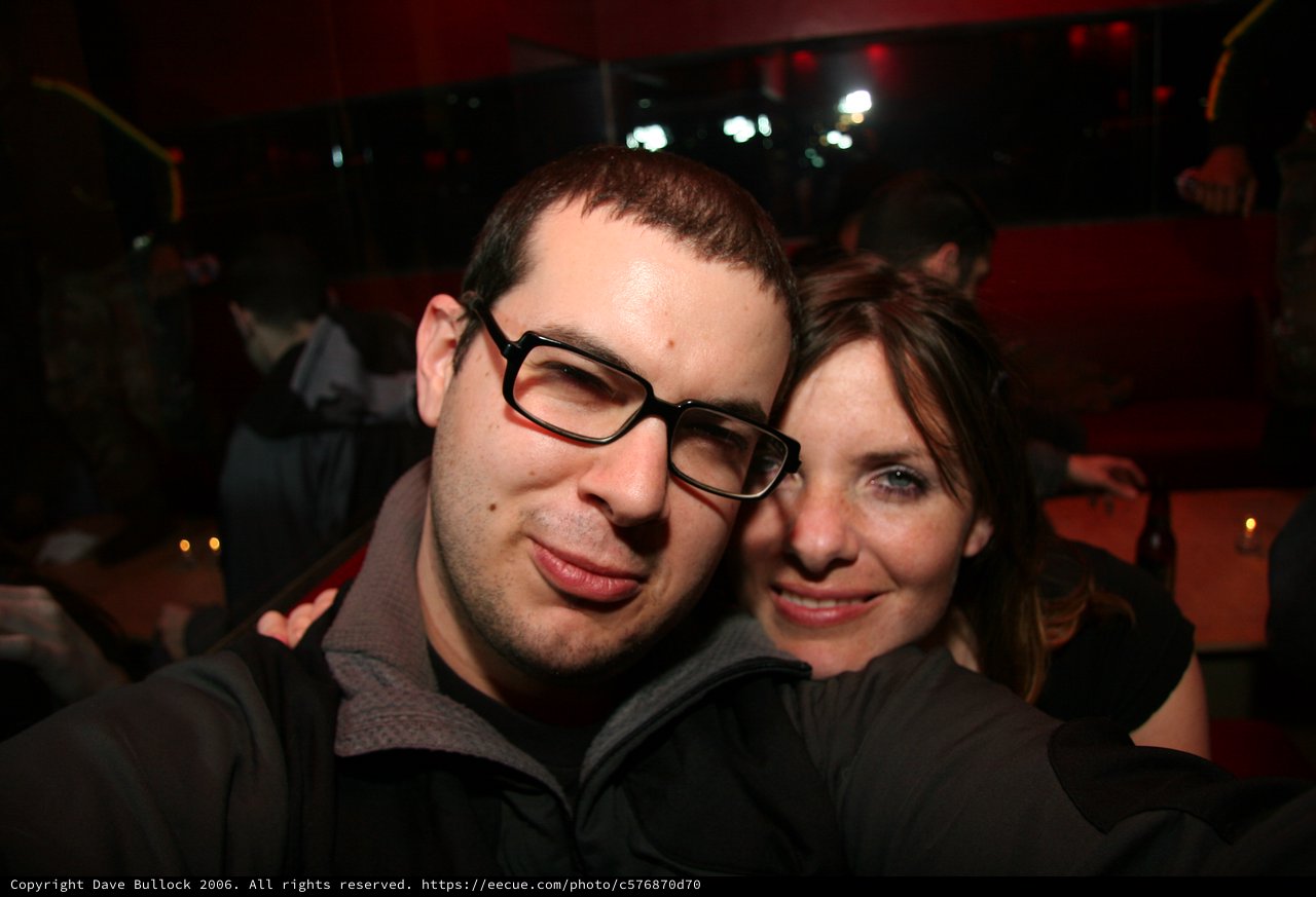 Couple Smiling Together at Dimly Lit Nightclub