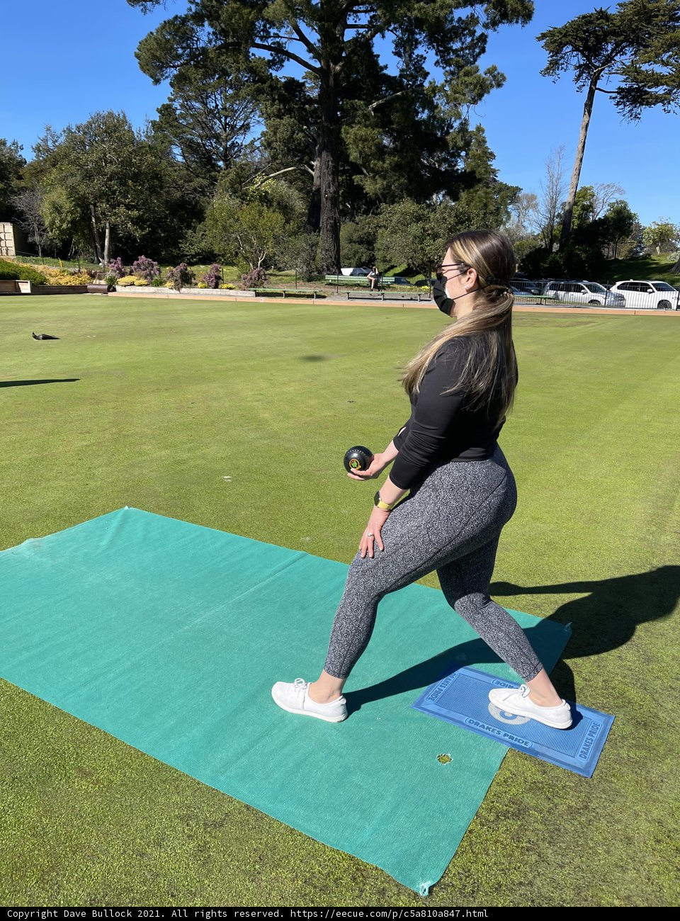 Warrior pose with tennis ball on a green mat