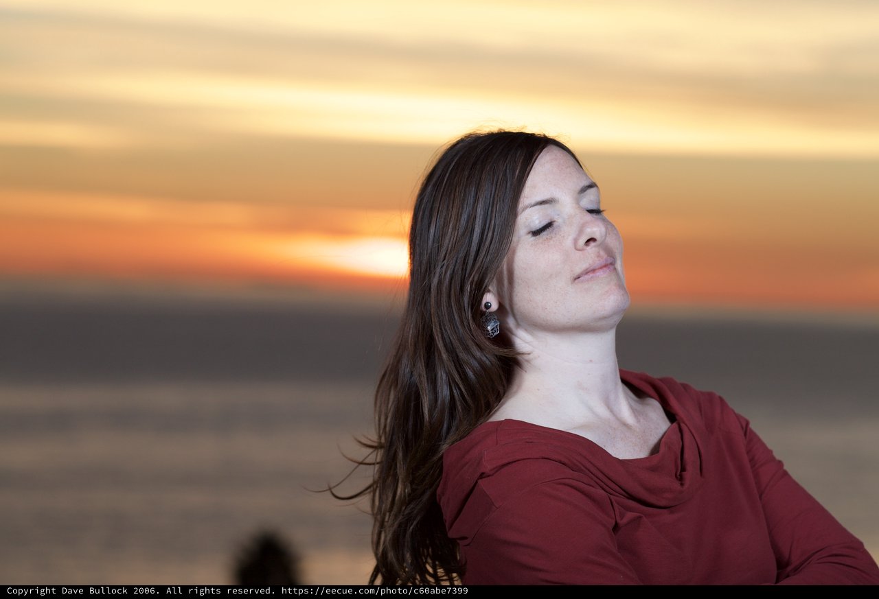 Serene Woman Embracing Golden Hour at Waterfront
