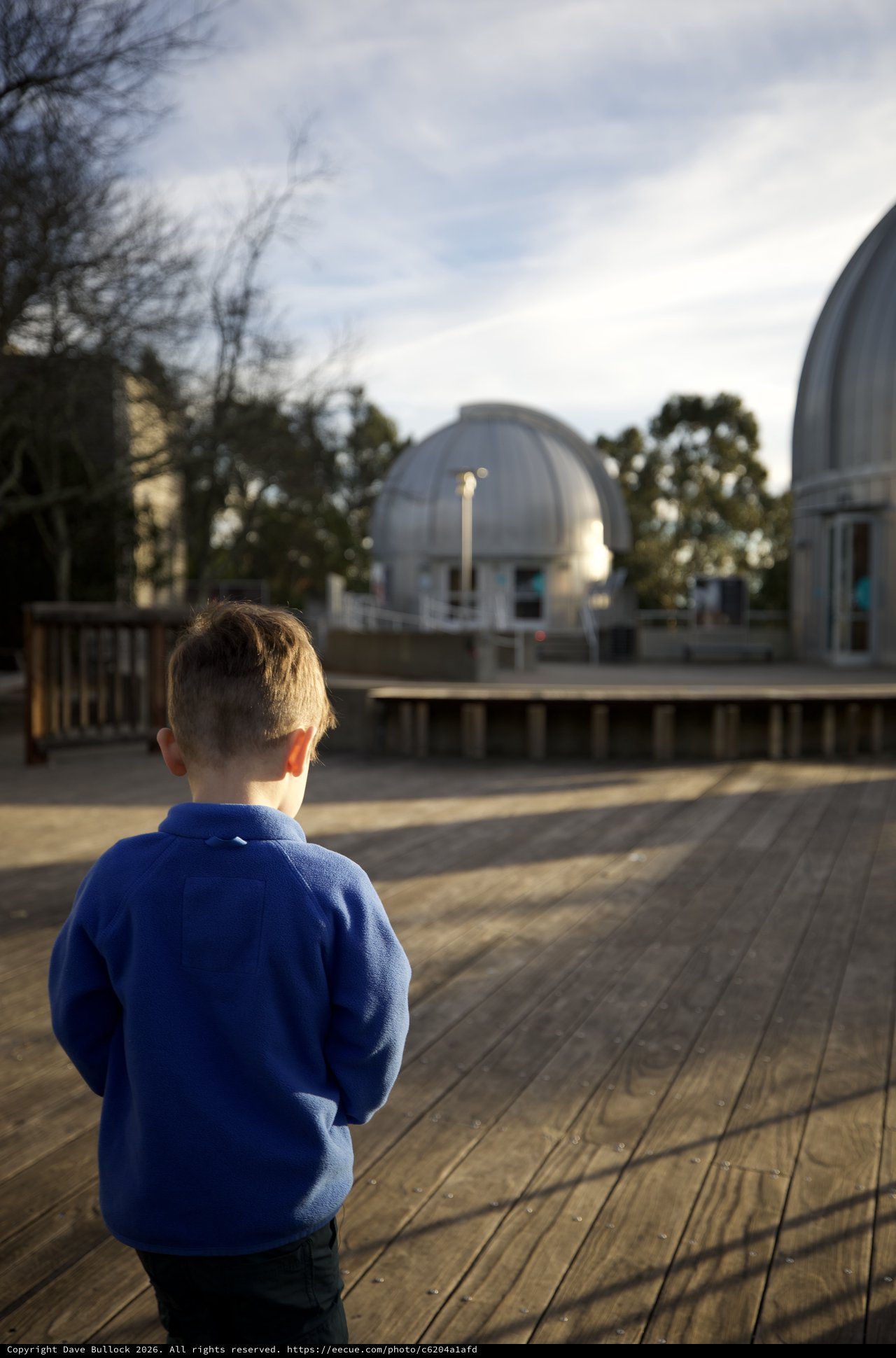 Young Boy Gazing at Observatory Domes at Dusk