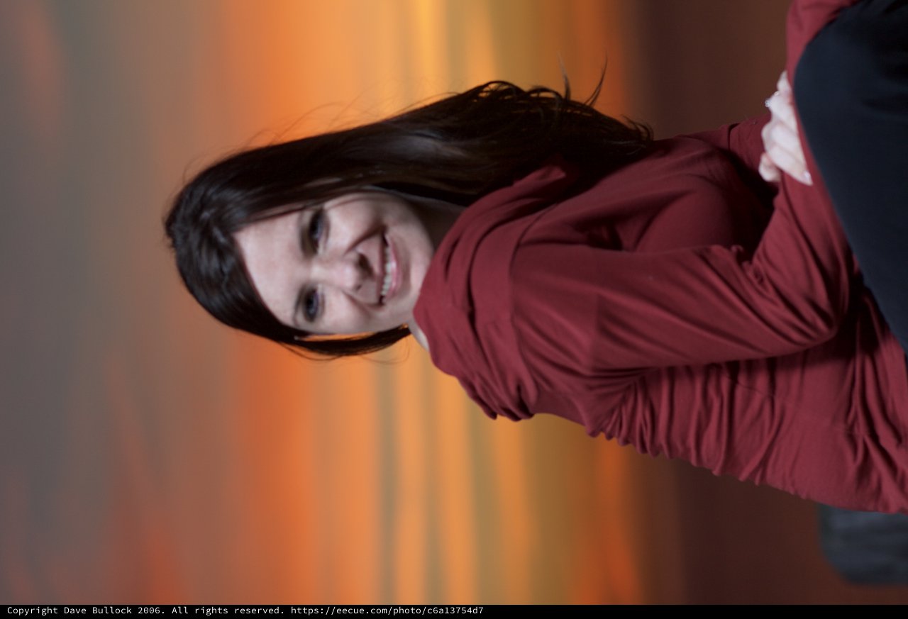Woman Smiling Against a Vibrant Sunset Sky