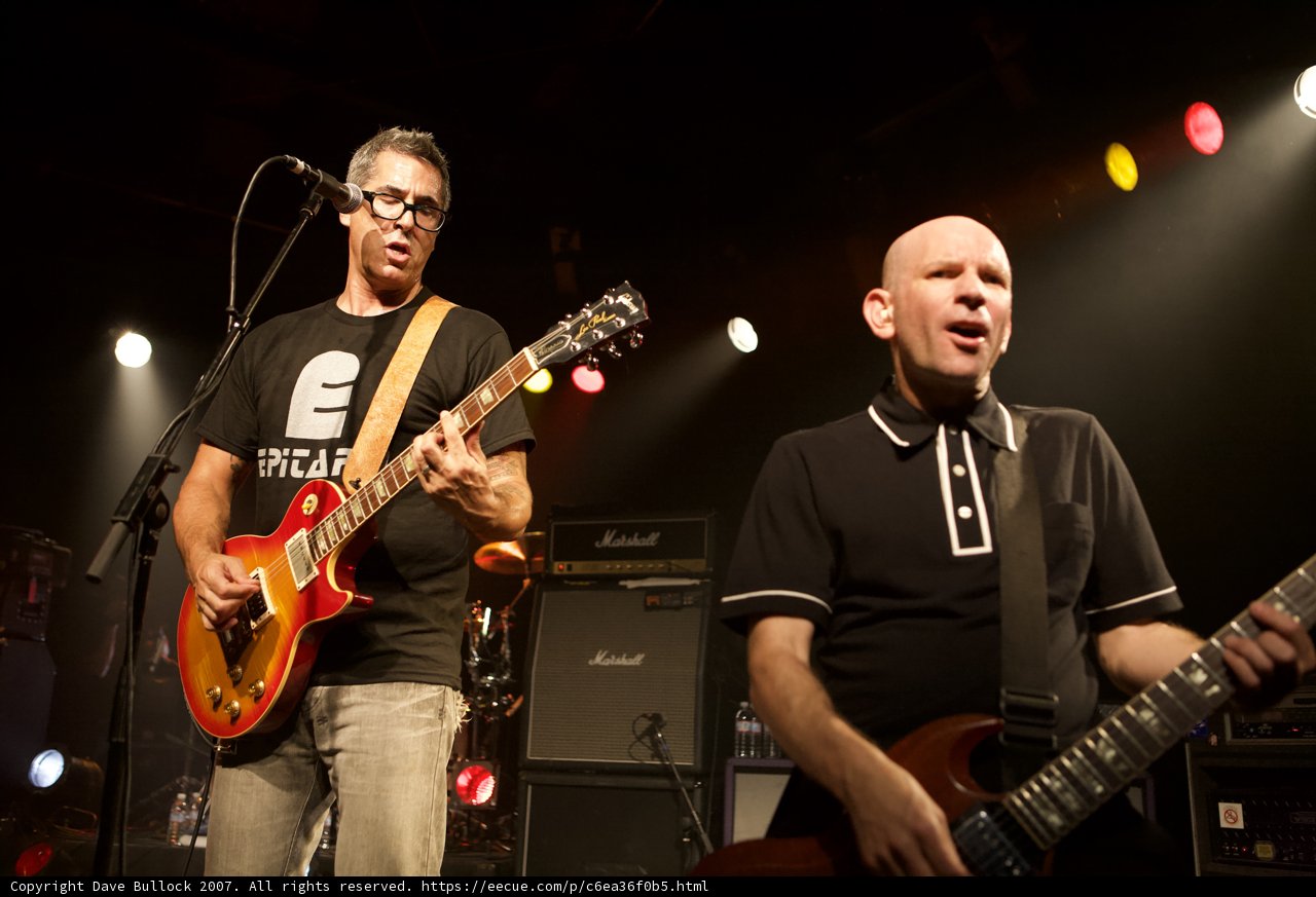 Two Men Strumming Their Guitars to the Beat