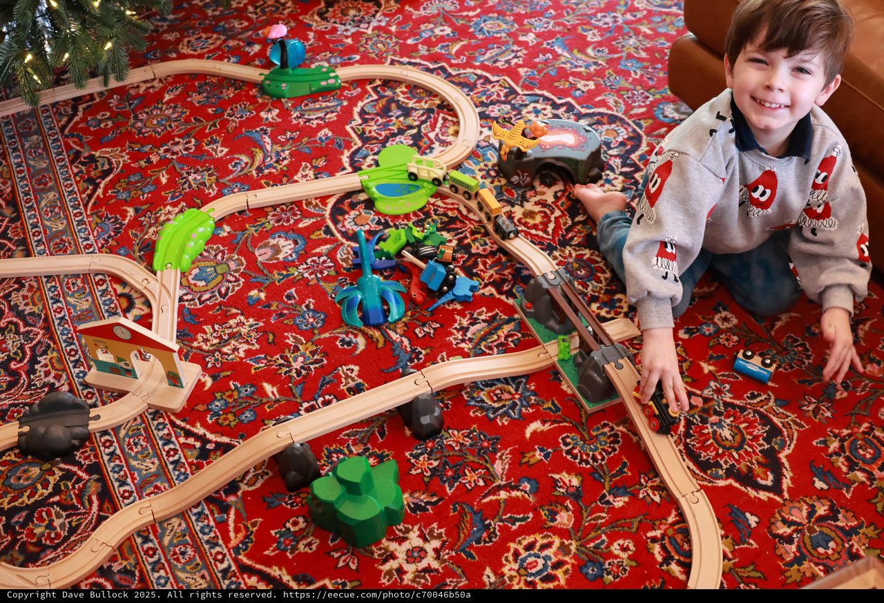 Young Boy Playing with Wooden Train Set on Christmas