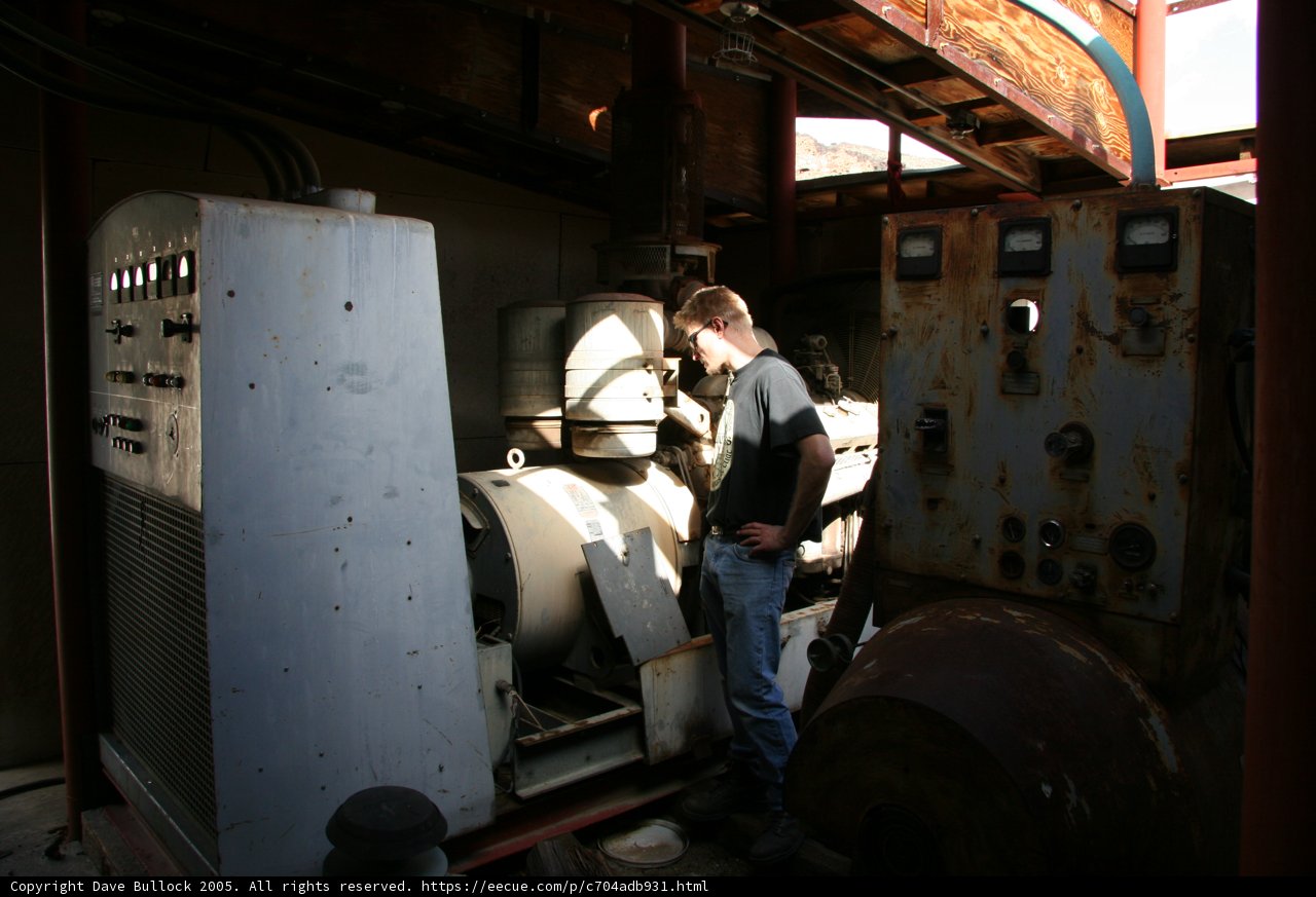 Man standing next to a large industrial generator