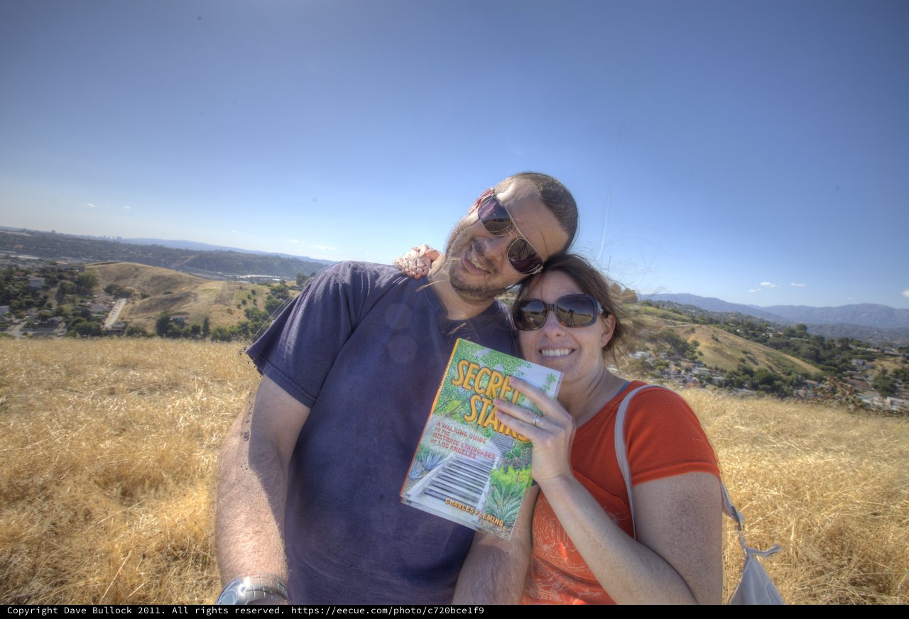 Couple Smiling Atop Los Angeles Hills with Guidebook