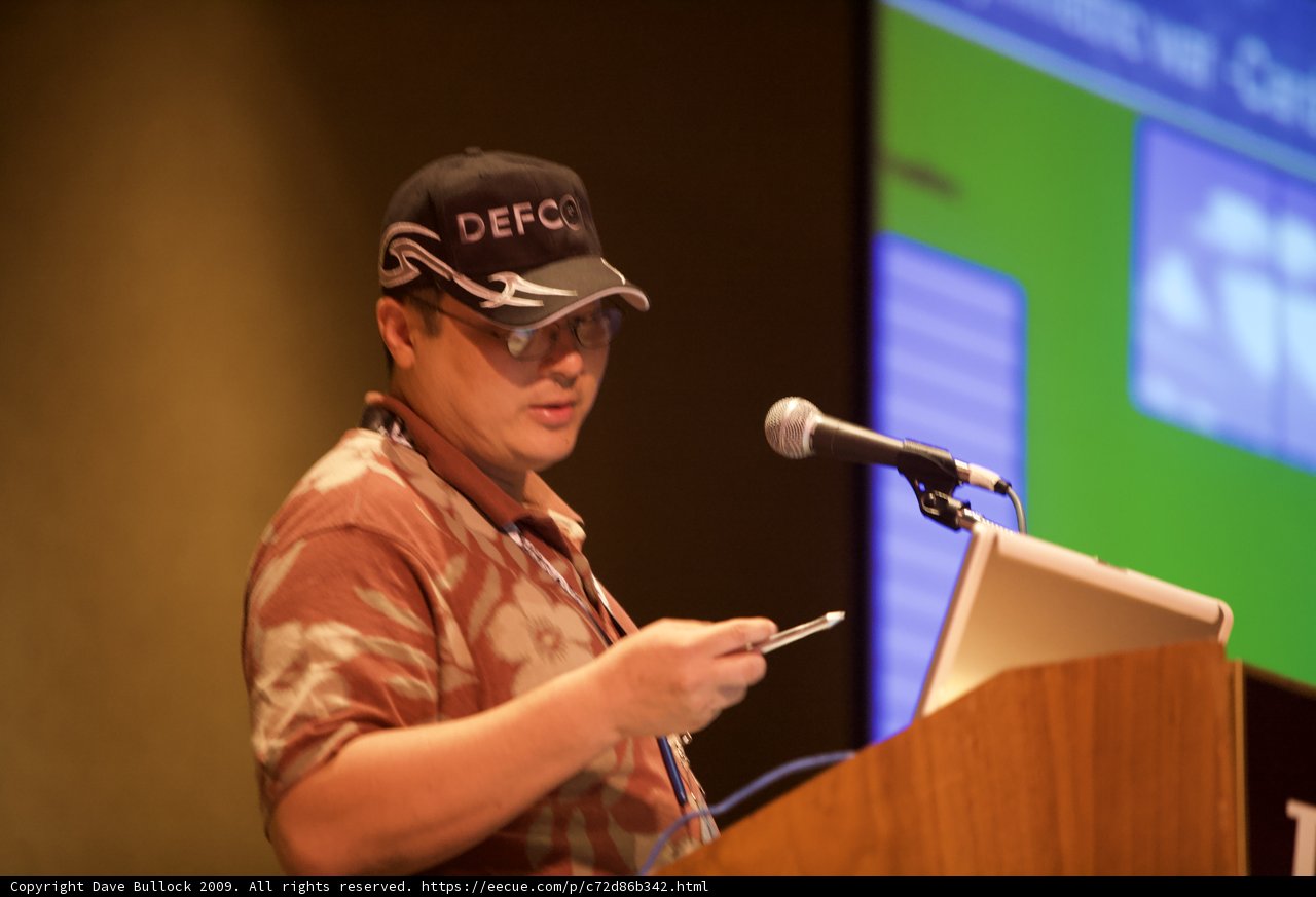Hideaki Wakui delivering a speech wearing a baseball hat
