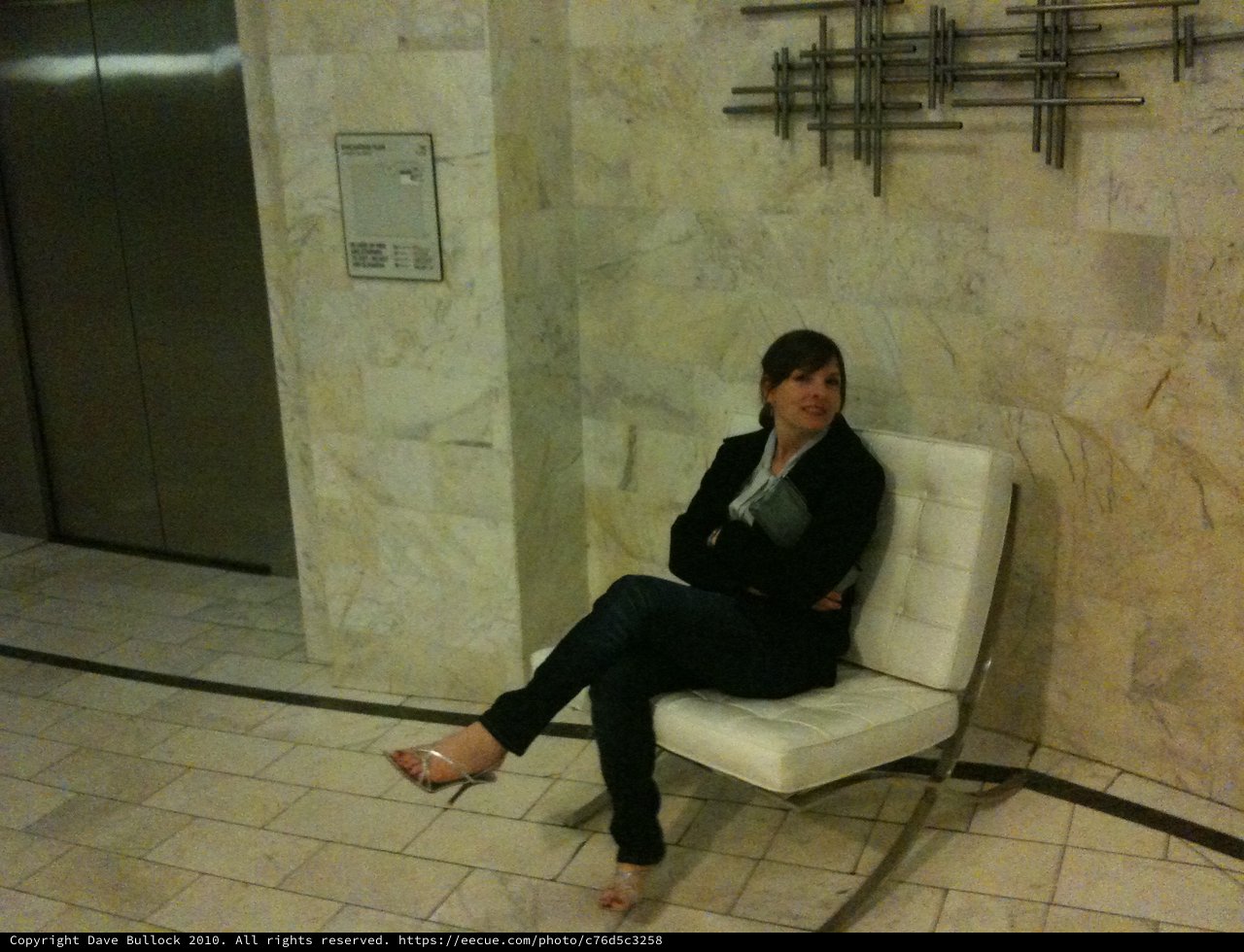 Woman Waiting in Corporate Building Lobby at Night