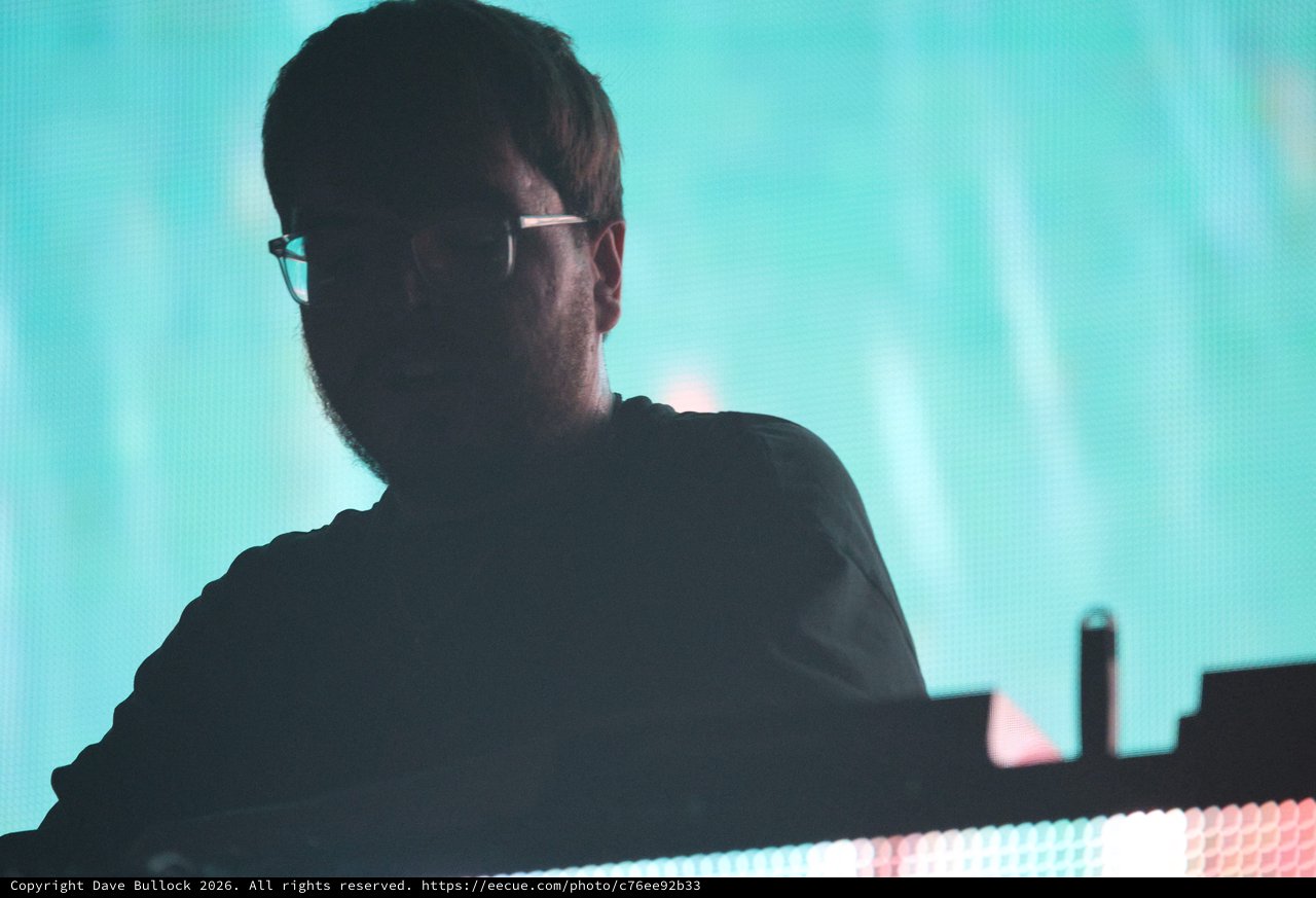 Silhouetted DJ Performs Beneath Teal Stage Lights