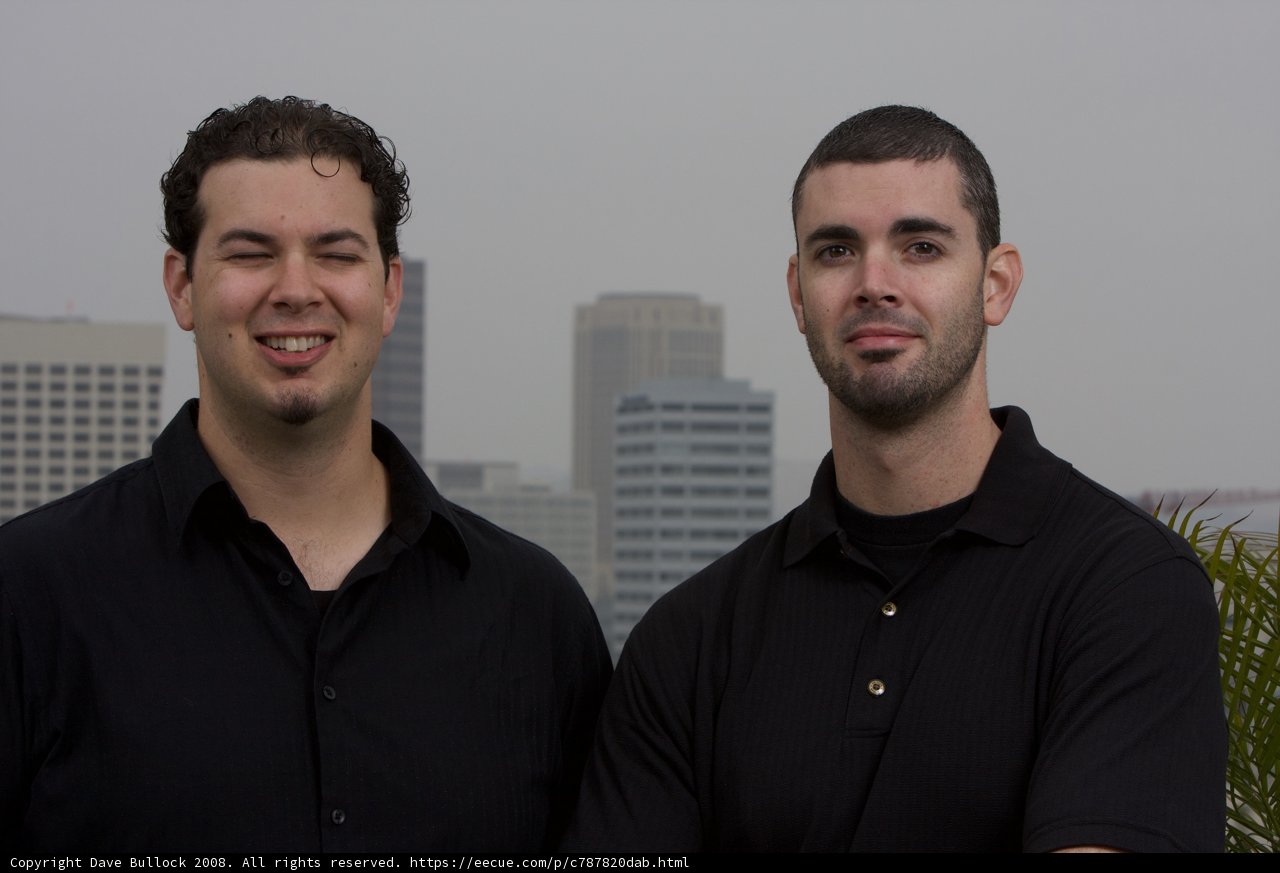 Two Happy Men Standing in Front of a Skyscraper