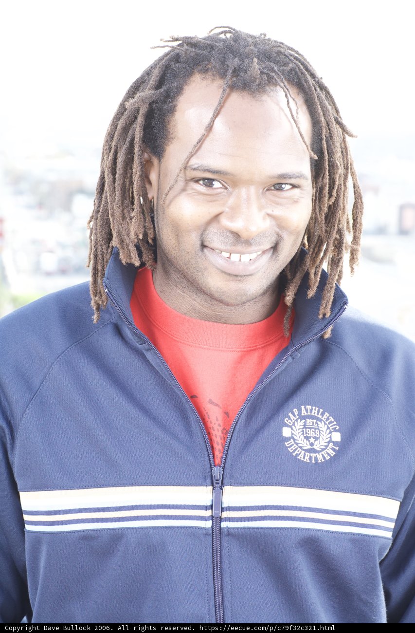 Happy man in colorful jacket and dreadlocks