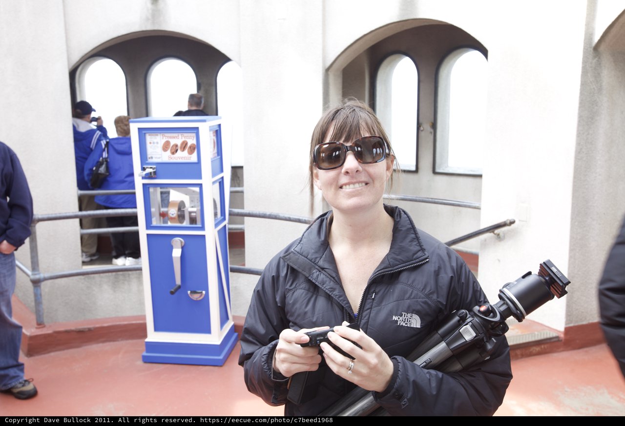 Photographer Smiling at Pressed Penny Souvenir Machine